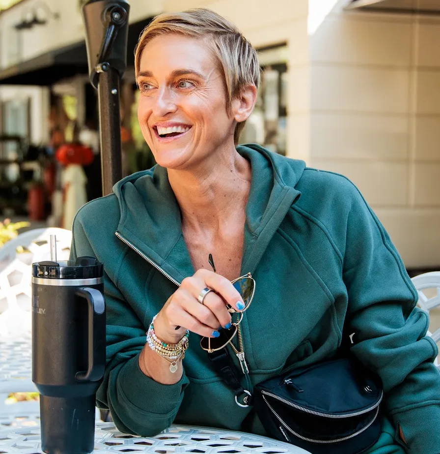 Julie Voris sitting at table with green jacket and water bottle